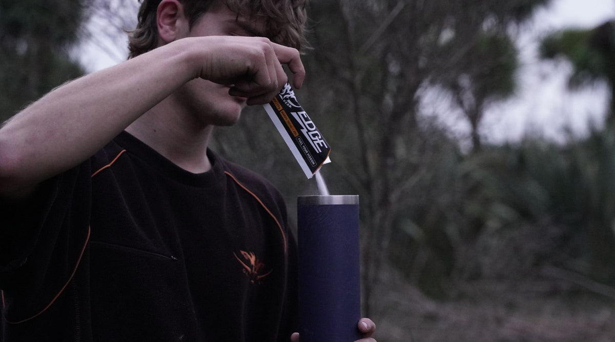 Pouring Game Gear Edge Hydration Powder into bottle